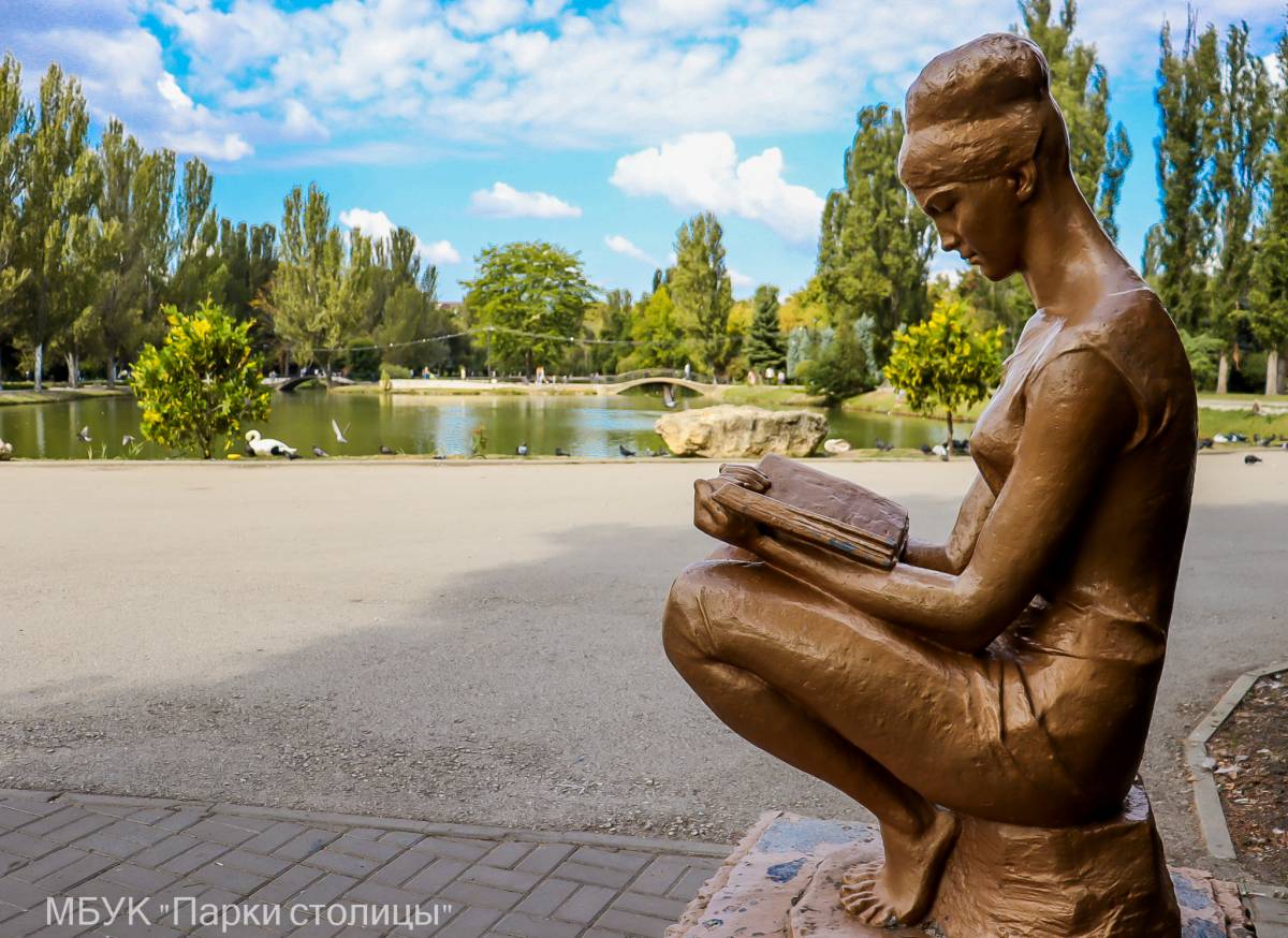 Памятник в парке: девушка, читающая книгу 